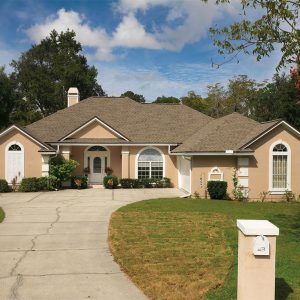 Light brown suburban home with white accents and asphalt roof