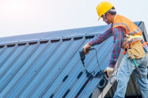 Roofer installing standing seam metal roof