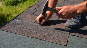 Roofing contractor installing asphalt shingle roof